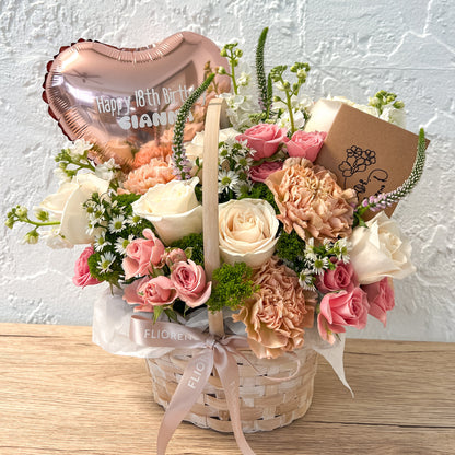 Floral arrangement in a basket with a 'Happy 18th Birthday' balloon 