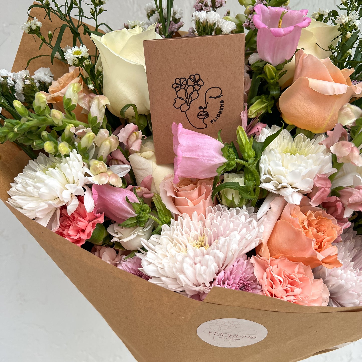 Bouquet of flowers with a card and brand label on a light background