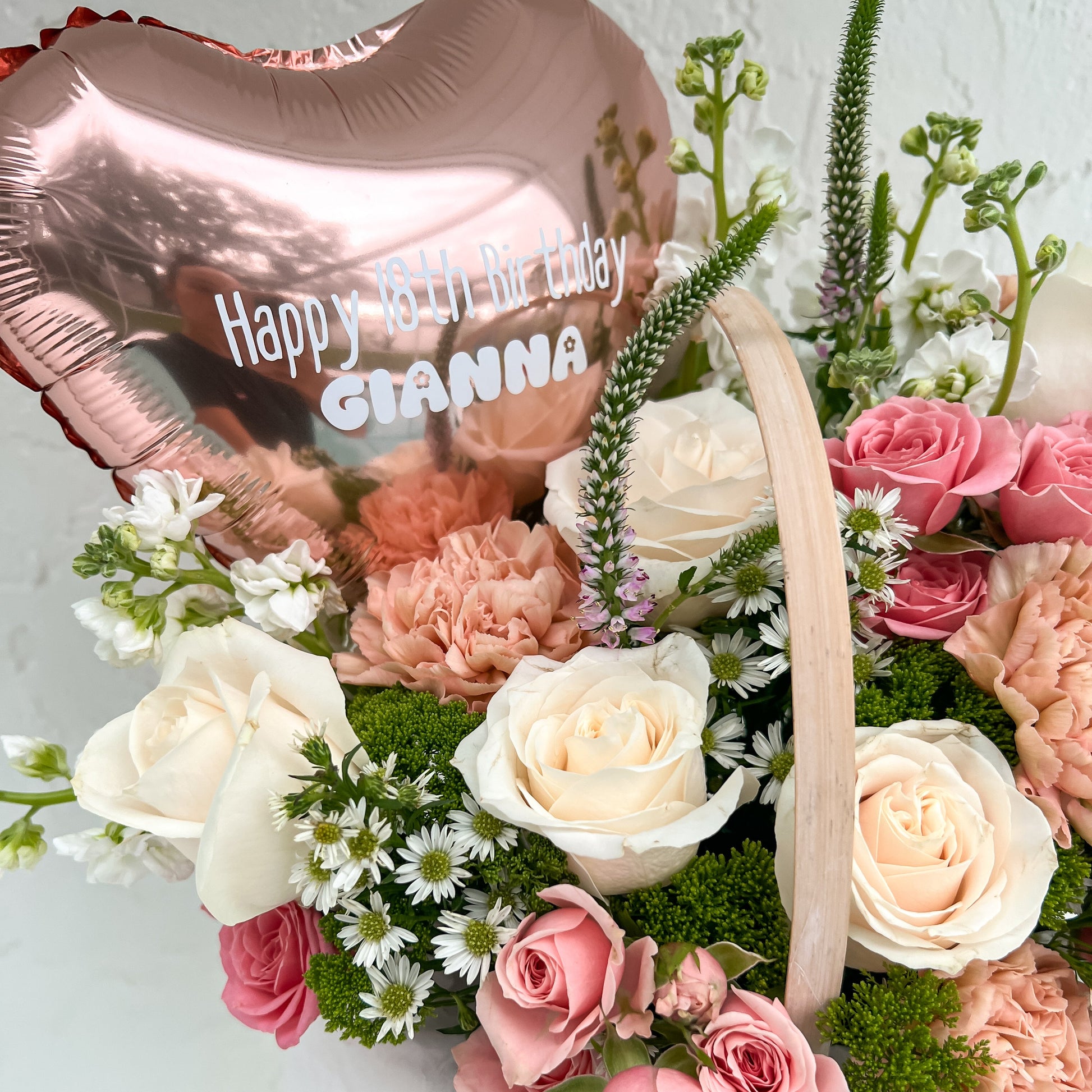 Floral arrangement with a heart-shaped balloon reading 'Happy Birthday'
