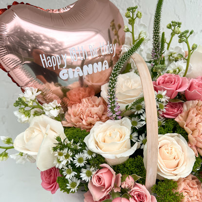 Floral arrangement with a heart-shaped balloon reading 'Happy Birthday'